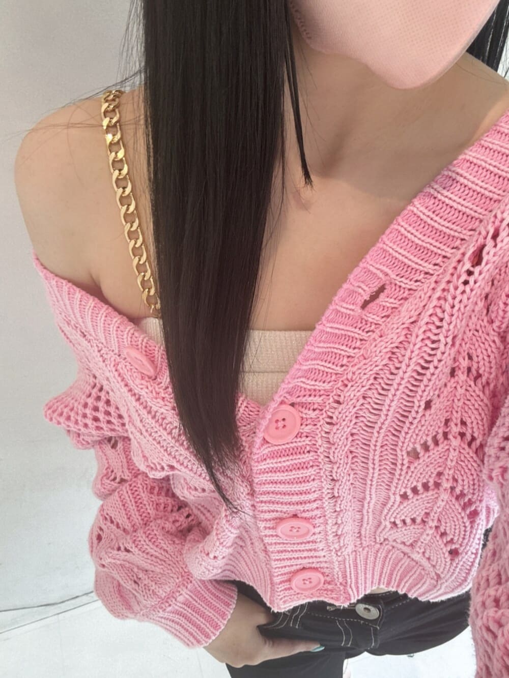 ブラック系のデニムパンツ、ホワイト系のキャミソール、ピンク系のニット/セーターを着用したレディースの春コーディネートの4枚目の写真