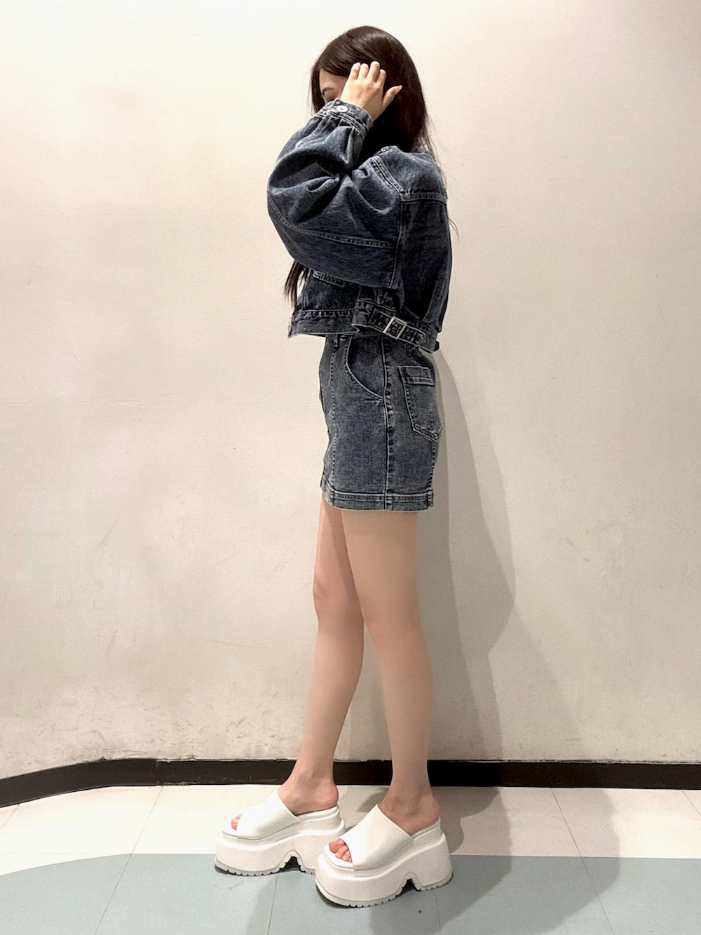 ブルー系のデニムジャケット、ブルー系のワンピース、ホワイト系のサンダルを着用したレディースの春コーディネートの2枚目の写真