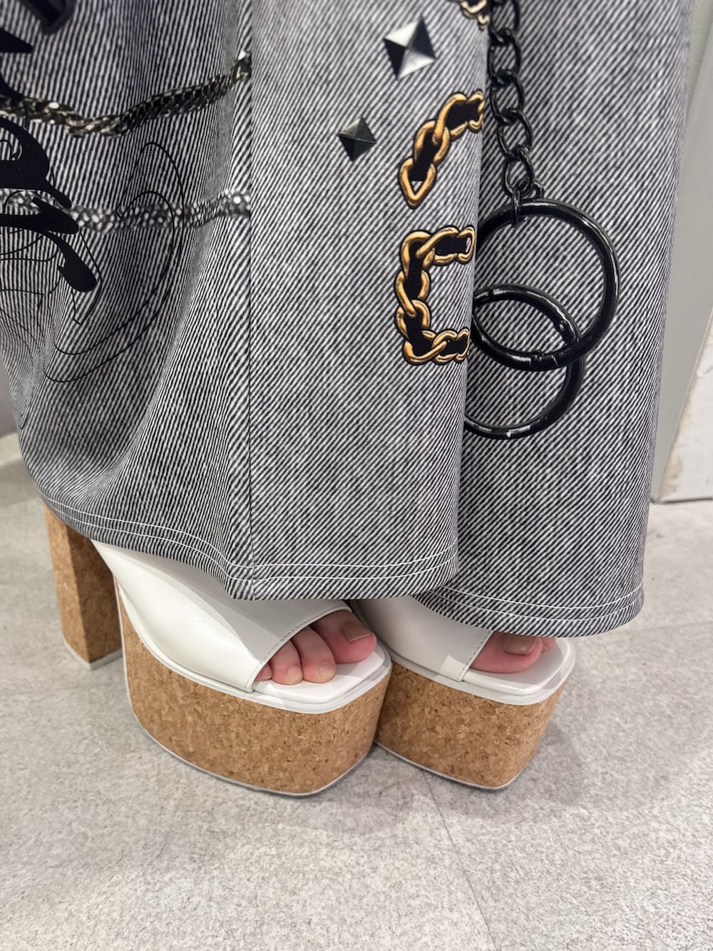 ホワイト系のキャミソール、ブラック系のデニムパンツ、ホワイト系のサンダルを着用したレディースの夏コーディネートの7枚目の写真