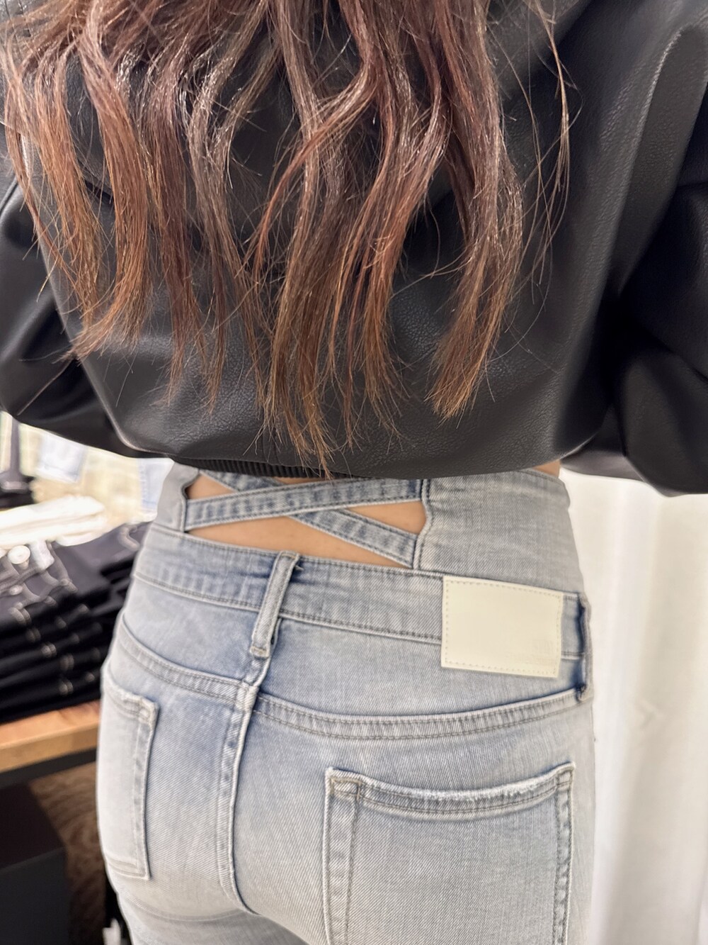 ブルー系のデニムパンツ、ホワイト系のTシャツ/カットソー、ブラック系のブルゾンを着用したレディースの春コーディネートの6枚目の写真