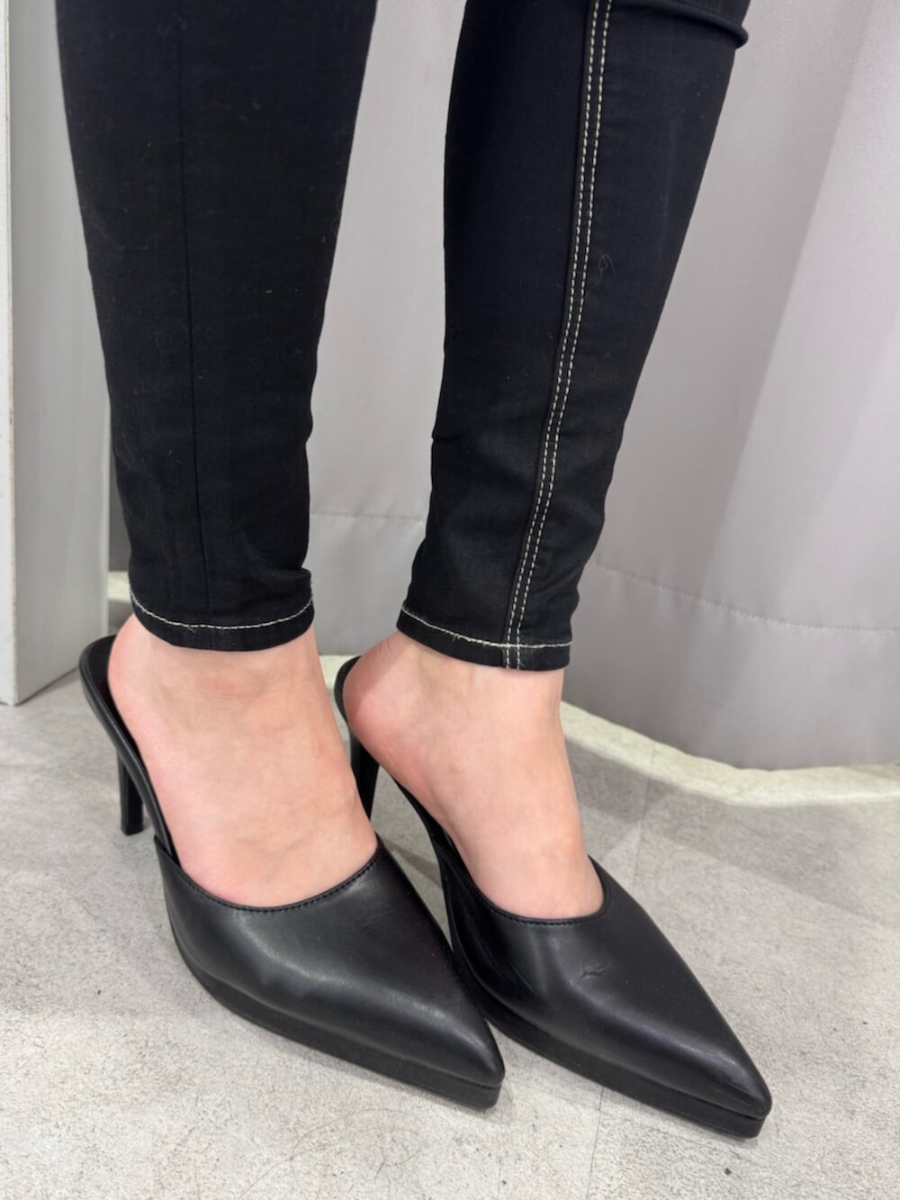 ホワイト系のニット/セーター、ブラック系のデニムパンツ、ブラック系のパンプスを着用したレディースの冬コーディネートの6枚目の写真