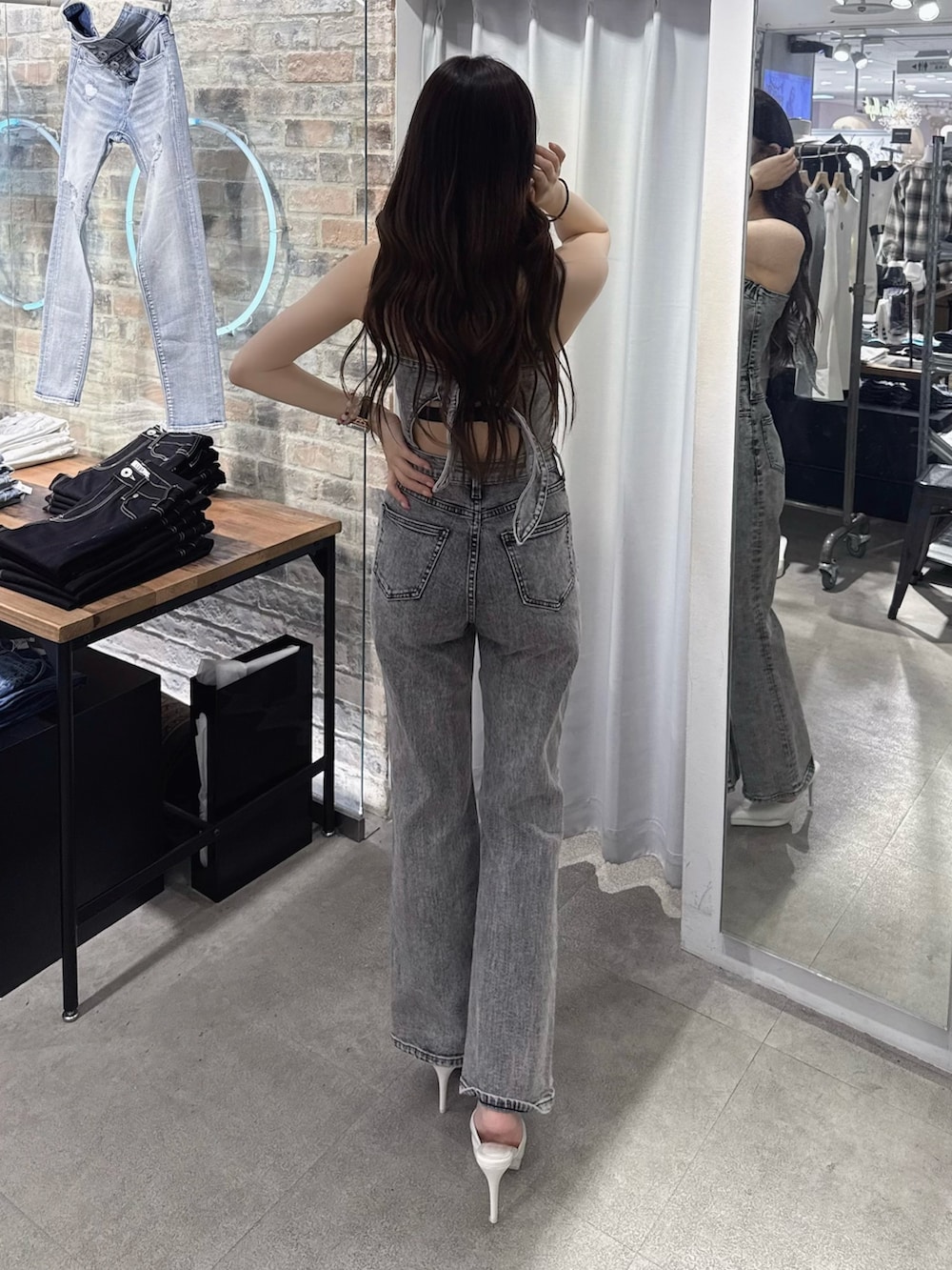 ブラック系のサロペット/オーバーオール、ホワイト系のパンプス、ホワイト系のカーディガン/ボレロを着用したレディースの春コーディネートの4枚目の写真