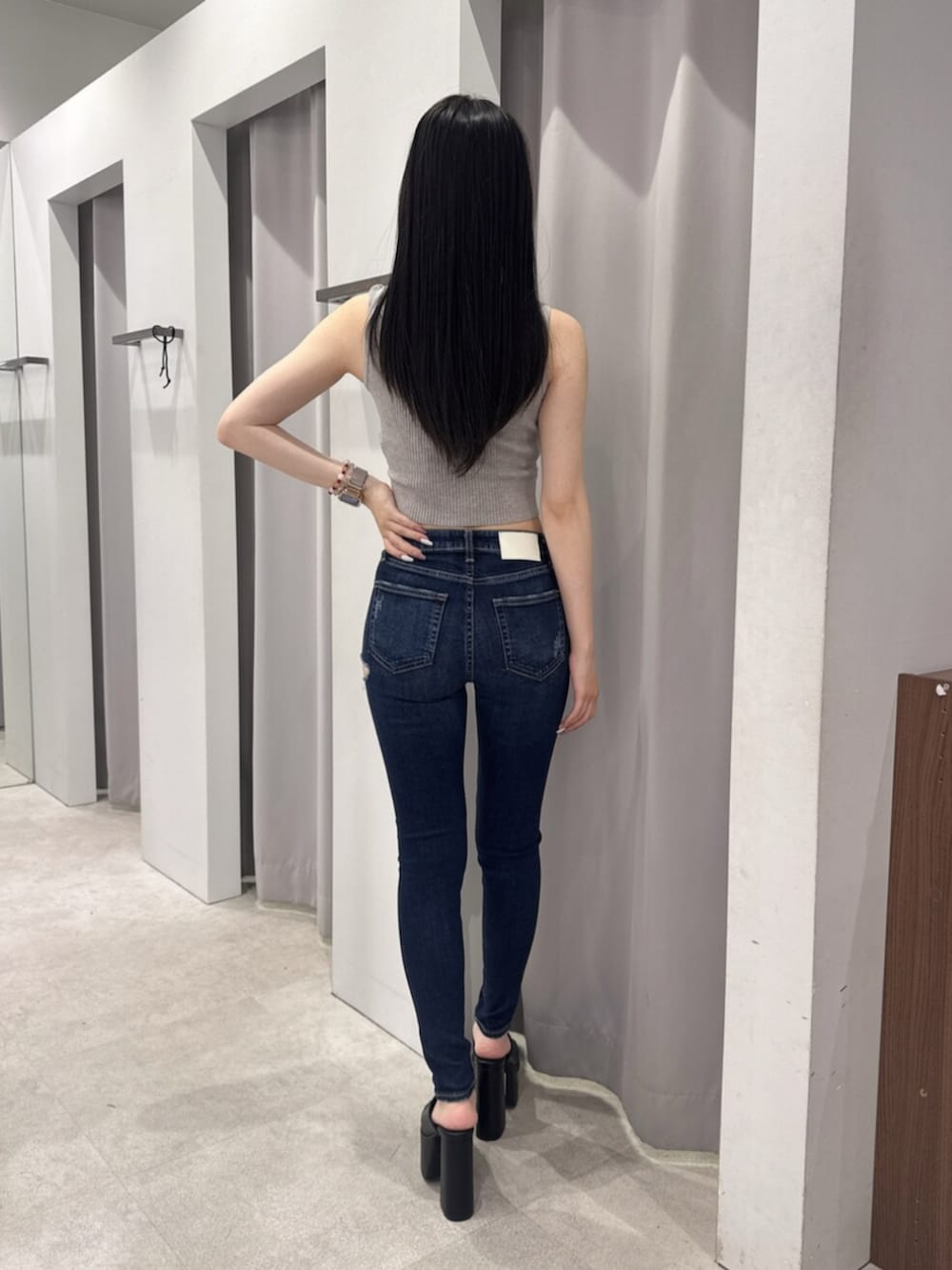 ブルー系のデニムパンツ、ブラック系のサンダル、グレー系のキャミソールを着用したレディースの夏コーディネートの3枚目の写真