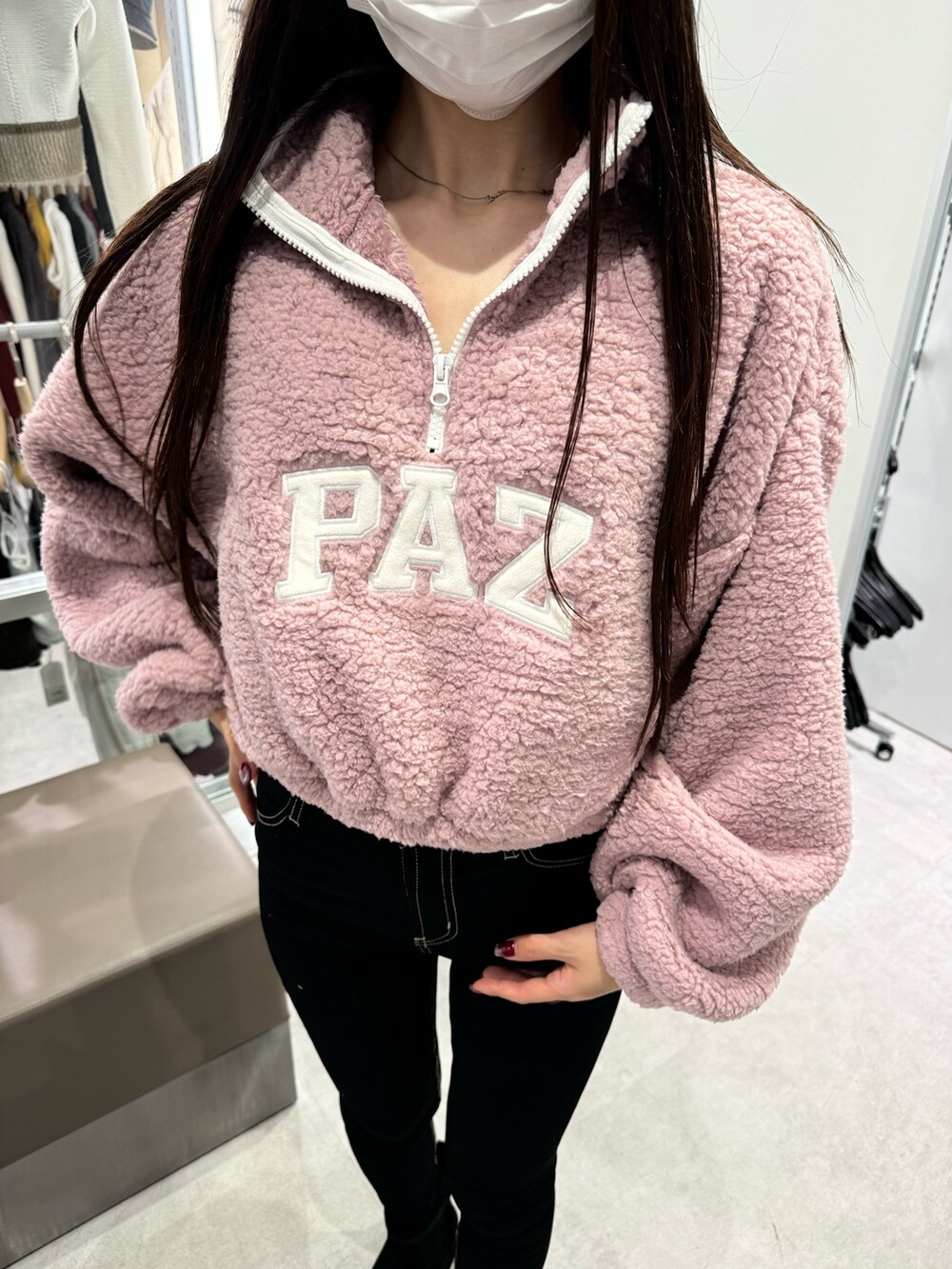 ピンク系のパーカー、ブラック系のデニムパンツ、ブラック系のブーツを着用したレディースの秋コーディネートの4枚目の写真