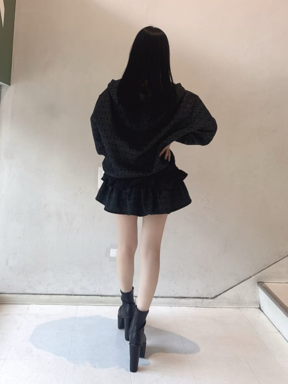 ブラック系のブーツ、ホワイト系のキャミソール、ブラック系のパーカーを着用したレディースの冬コーディネートの3枚目の写真