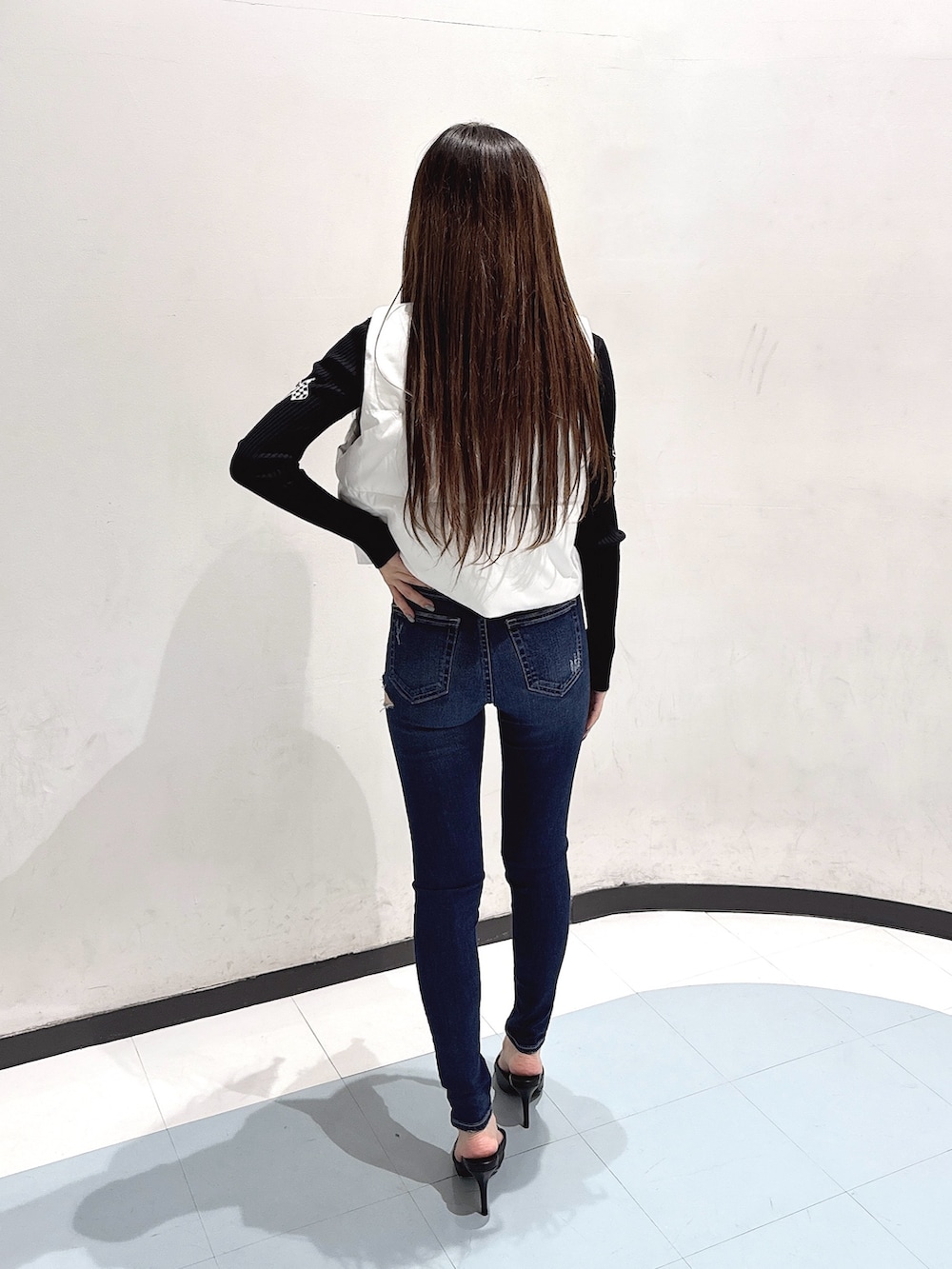 ブルー系のデニムパンツ、ブラック系のパンプス、ブラック系のニット/セーターを着用したレディースの秋コーディネートの3枚目の写真