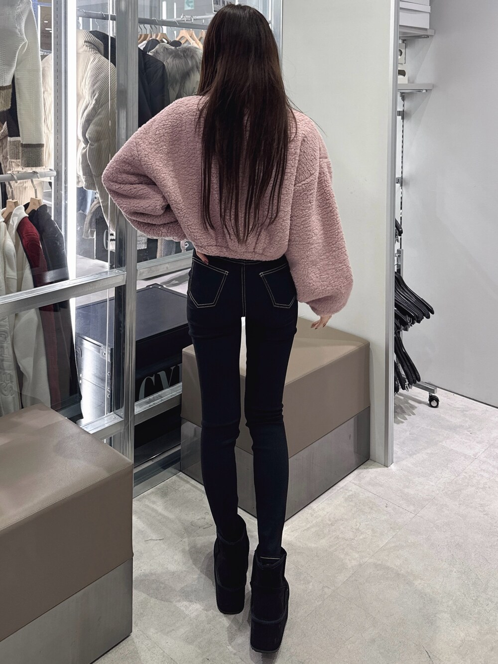 ピンク系のパーカー、ブラック系のデニムパンツ、ブラック系のブーツを着用したレディースの秋コーディネートの3枚目の写真