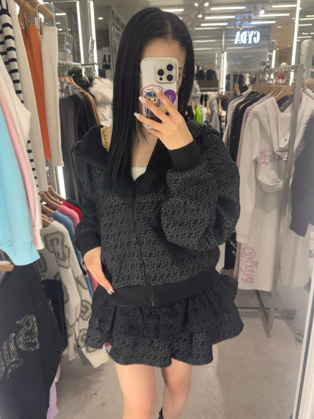 ブラック系のブーツ、ホワイト系のキャミソール、ブラック系のパーカーを着用したレディースの冬コーディネートの4枚目の写真