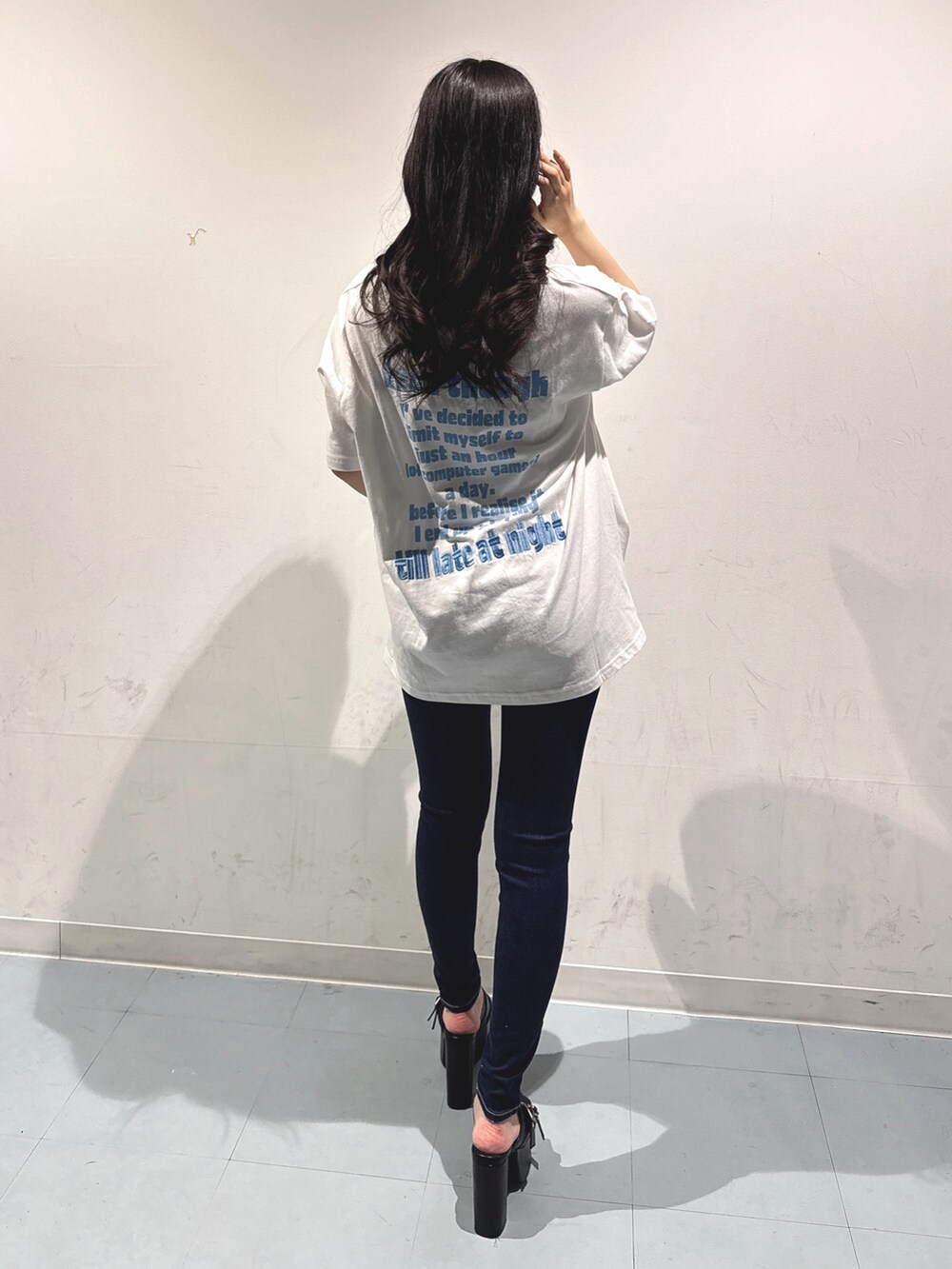 ホワイト系のTシャツ/カットソー、ブラック系のサンダル、ブルー系のデニムパンツを着用したレディースの夏コーディネートの3枚目の写真