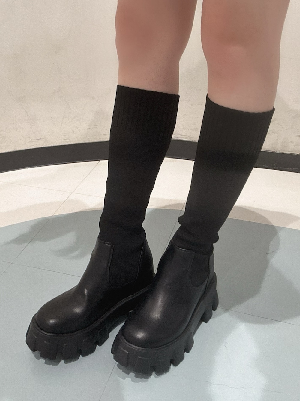 ホワイト系のカーディガン/ボレロ、ホワイト系のキャミソール、ブラック系のスカートを着用したレディースの秋コーディネートの5枚目の写真