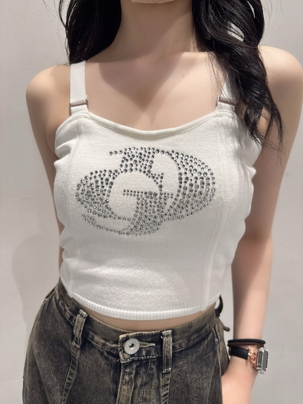 ホワイト系のキャミソール、ブルー系のデニムパンツ、ホワイト系のハンドバッグを着用したレディースの夏コーディネートの4枚目の写真