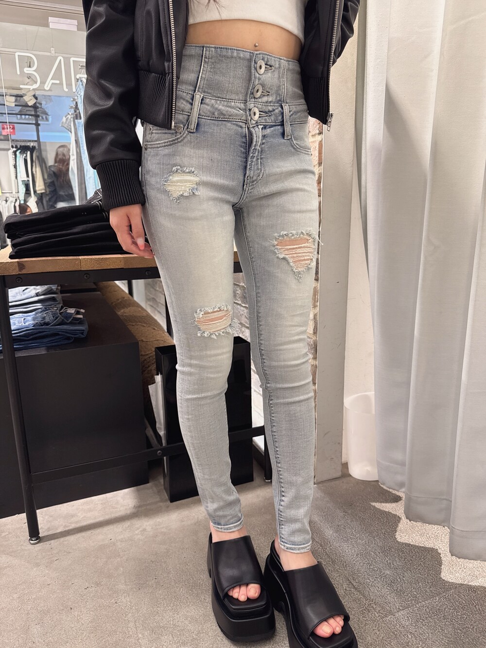 ブルー系のデニムパンツ、ホワイト系のTシャツ/カットソー、ブラック系のブルゾンを着用したレディースの春コーディネートの5枚目の写真