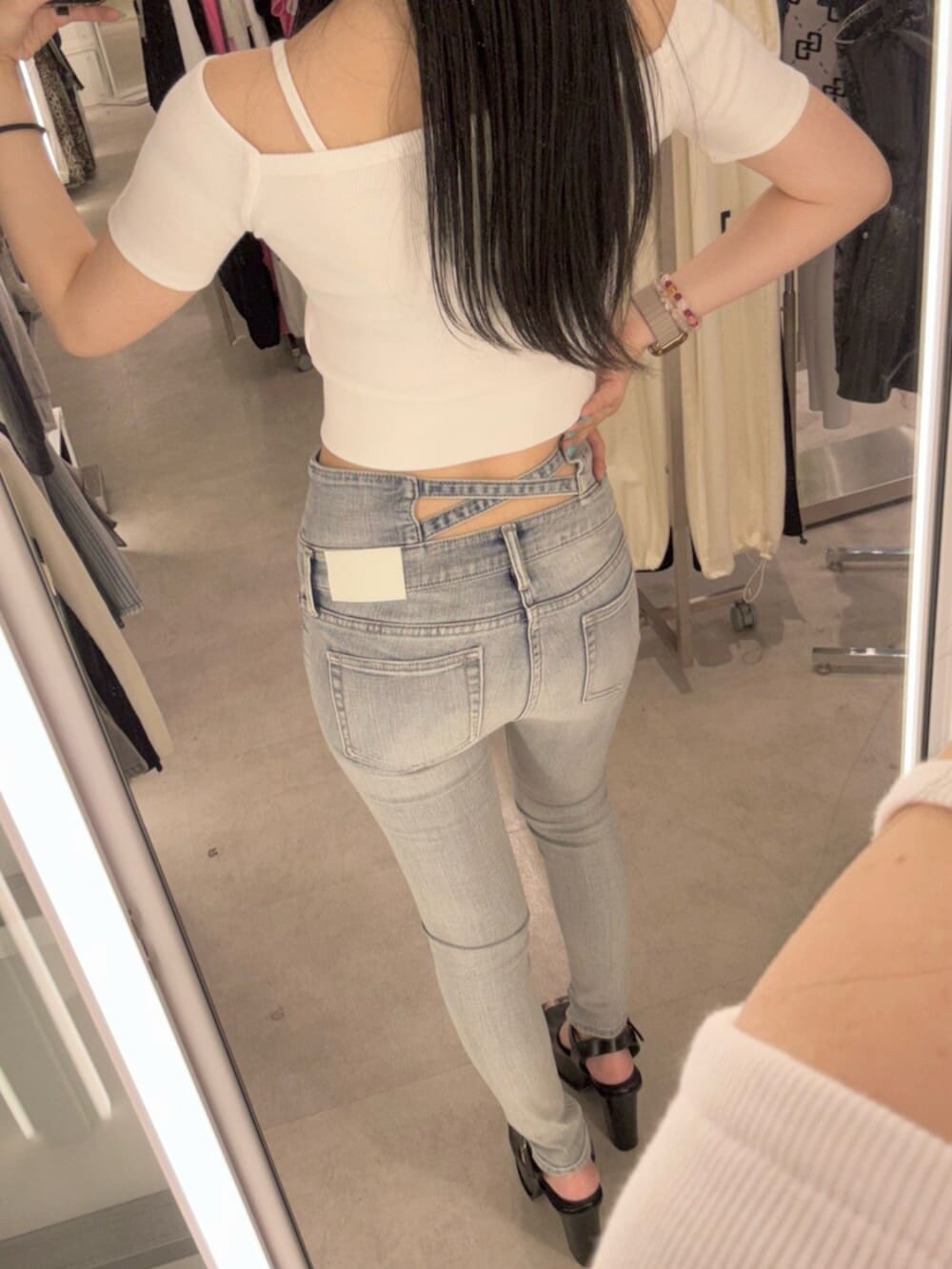 ホワイト系のTシャツ/カットソー、ブルー系のデニムパンツ、ブラック系のサンダルを着用したレディースの春コーディネートの6枚目の写真