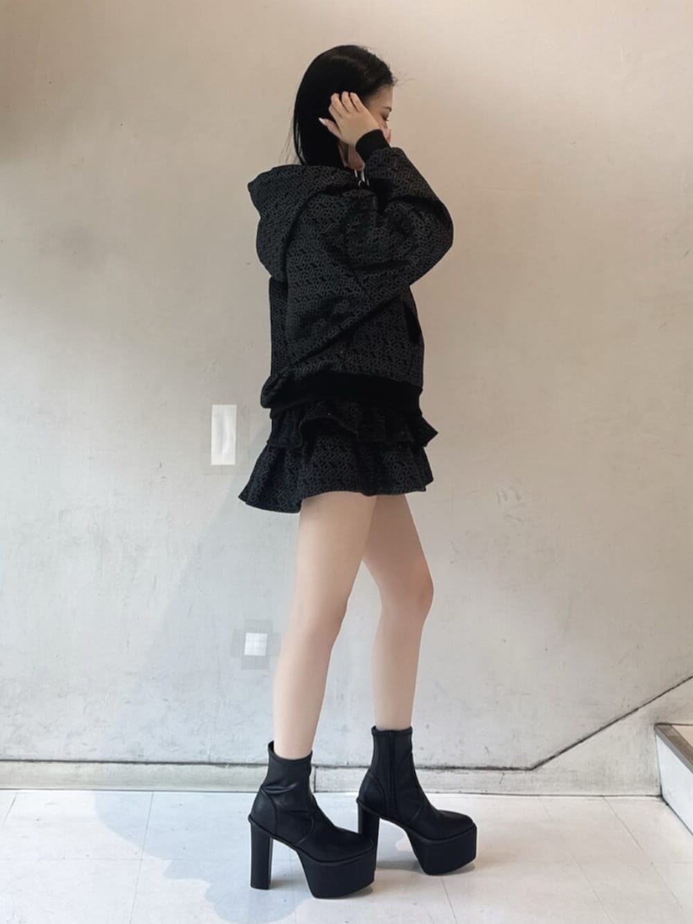 ブラック系のブーツ、ホワイト系のキャミソール、ブラック系のパーカーを着用したレディースの冬コーディネートの2枚目の写真