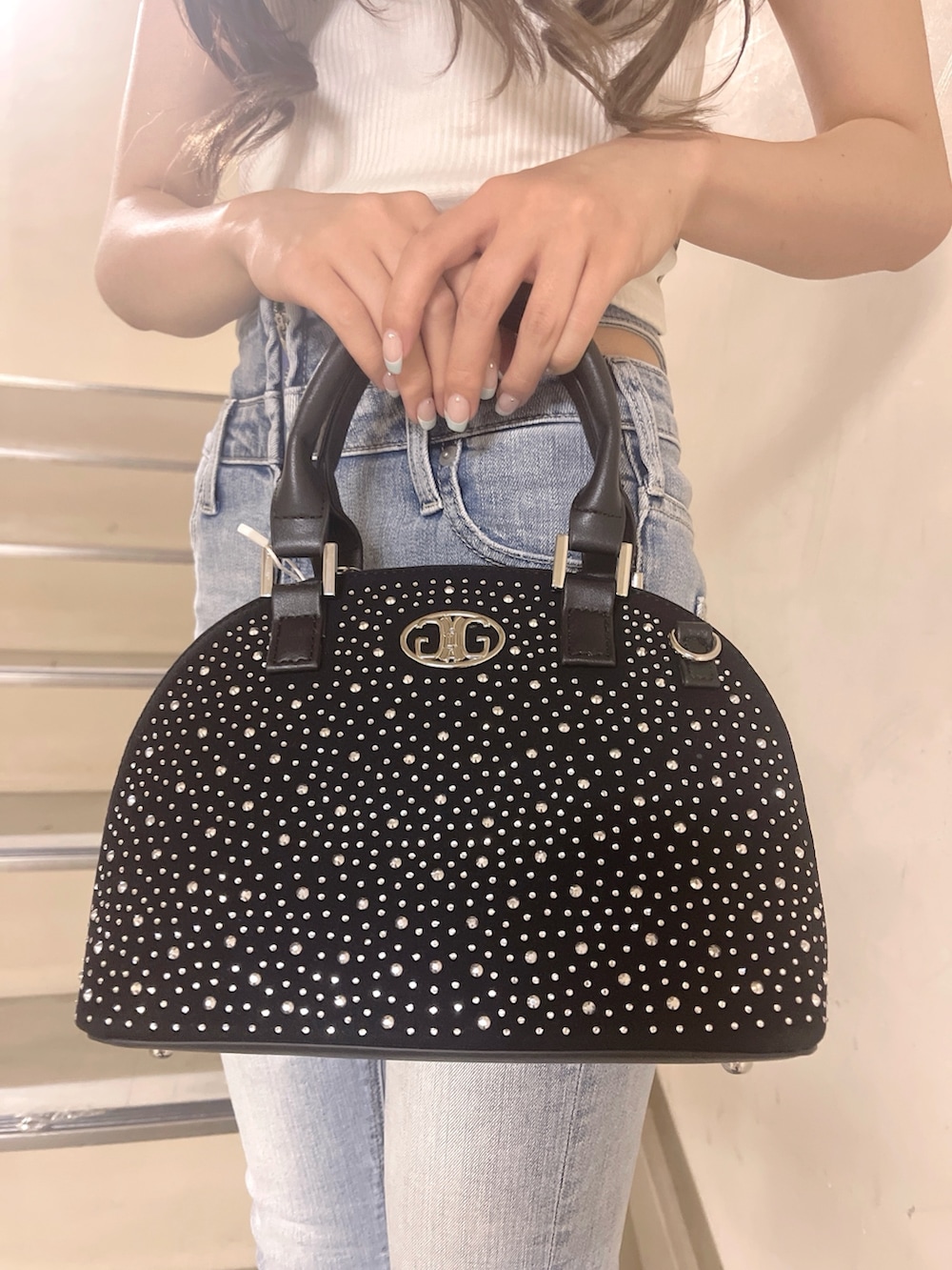 ブラック系のハンドバッグ、ブルー系のデニムパンツ、ホワイト系のTシャツ/カットソーを着用したレディースの春コーディネートの8枚目の写真