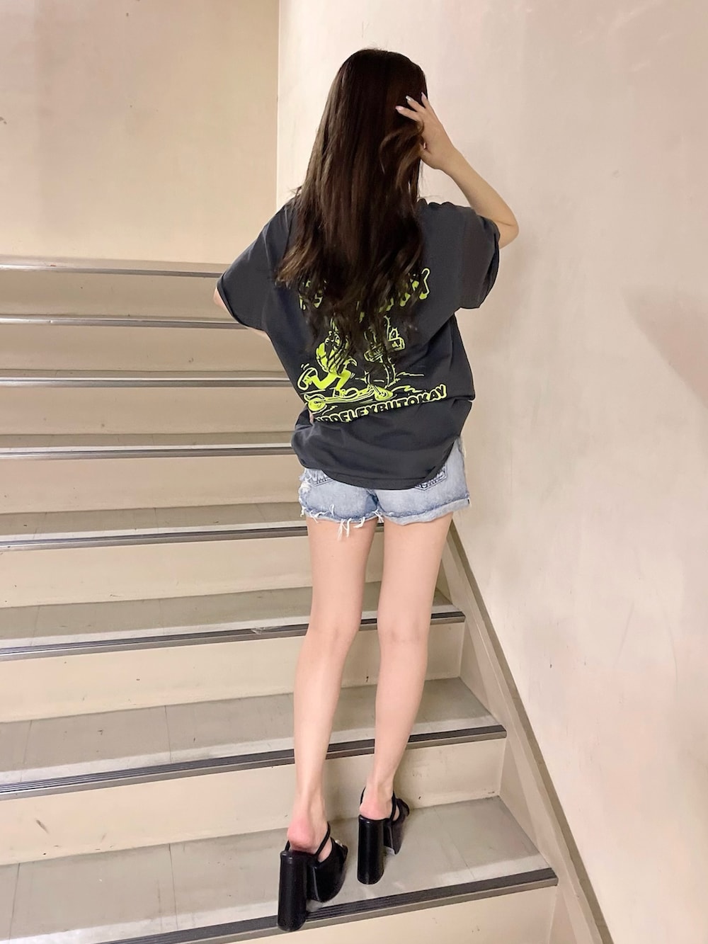 ブルー系のデニムパンツ、グレー系のTシャツ/カットソー、ブラック系のサンダルを着用したレディースの春コーディネートの3枚目の写真