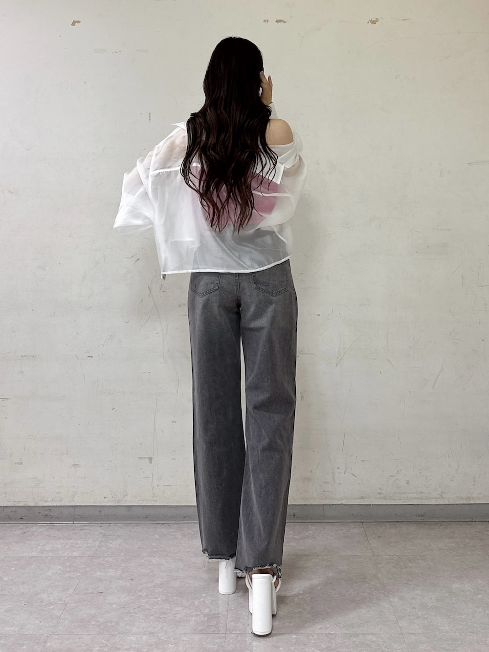 ピンク系のチューブトップ、ホワイト系のシャツ/ブラウス、グレー系のデニムパンツを着用したレディースの春コーディネートの3枚目の写真