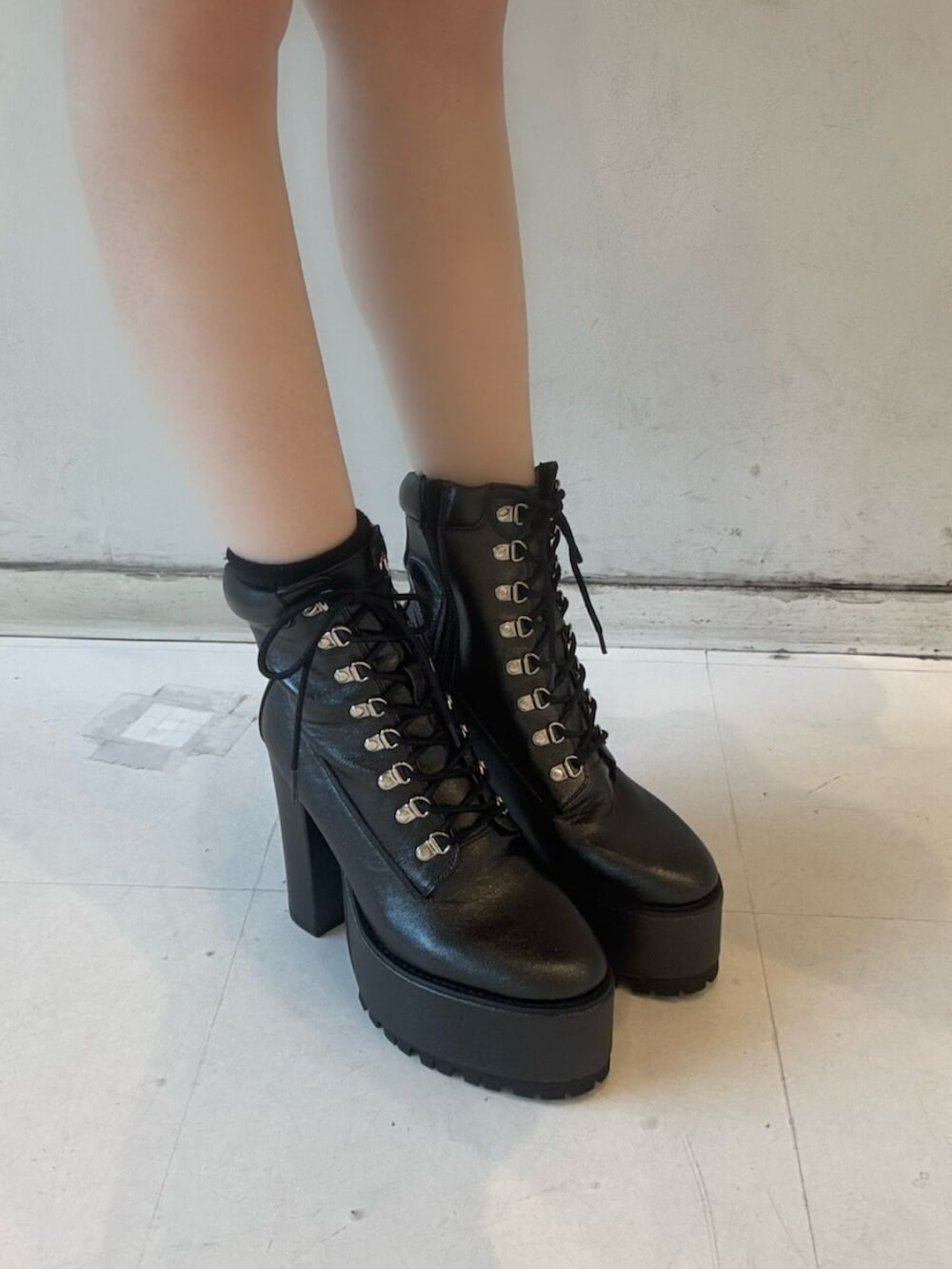 ブラック系のデニムスカート、ホワイト系のTシャツ/カットソー、ブラック系のブルゾンを着用したレディースの冬コーディネートの5枚目の写真