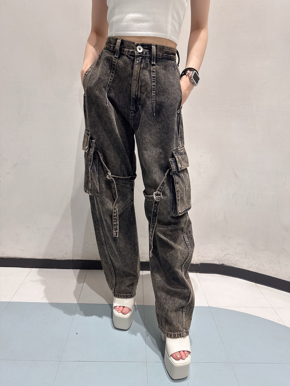 ホワイト系のキャミソール、ブルー系のデニムパンツ、ホワイト系のハンドバッグを着用したレディースの夏コーディネートの5枚目の写真