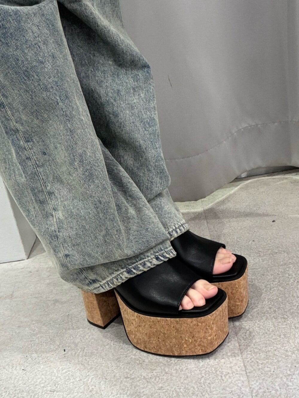 ブラック系のサンダル、ホワイト系のキャミソール、ブルー系のデニムパンツを着用したレディースの夏コーディネートの6枚目の写真