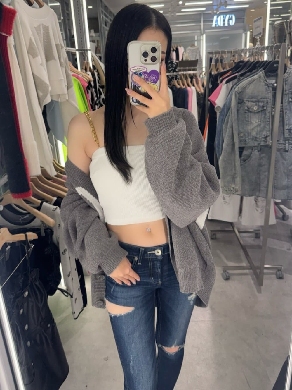 ホワイト系のチューブトップ、グレー系のカーディガン/ボレロ、ブルー系のデニムパンツを着用したレディースの春コーディネートの5枚目の写真