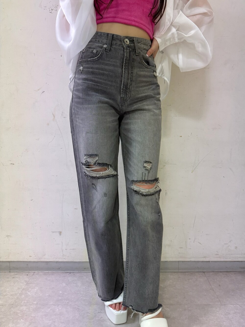 ピンク系のチューブトップ、ホワイト系のシャツ/ブラウス、グレー系のデニムパンツを着用したレディースの春コーディネートの4枚目の写真