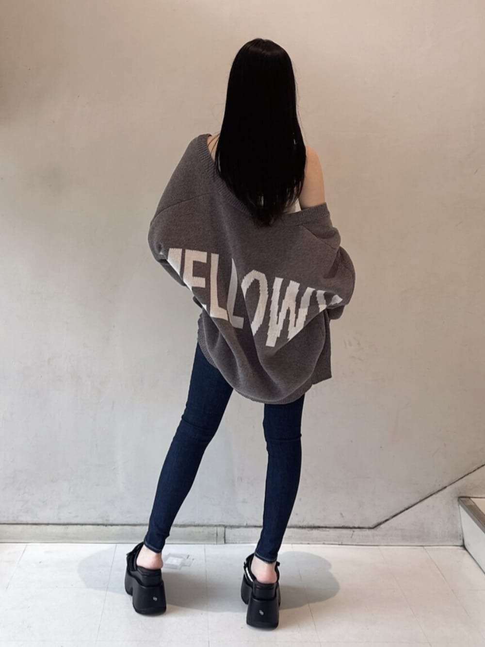 ホワイト系のチューブトップ、グレー系のカーディガン/ボレロ、ブルー系のデニムパンツを着用したレディースの春コーディネートの3枚目の写真