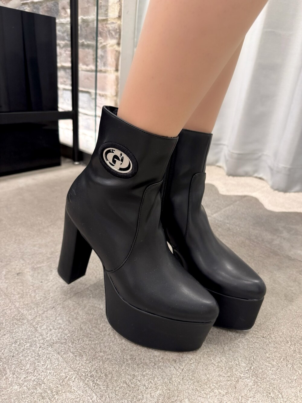 ブラック系のニット/セーター、ブラック系のデニムスカート、ホワイト系のハンドバッグを着用したレディースの冬コーディネートの6枚目の写真