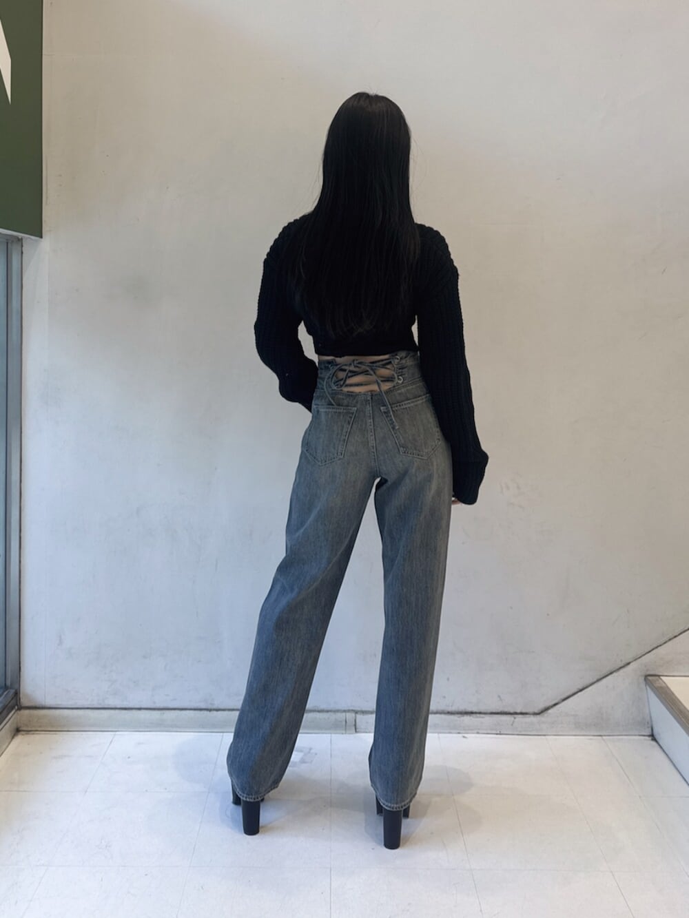 ブラック系のニット/セーター、ブルー系のデニムパンツ、ブラック系のブーツを着用したレディースの冬コーディネートの3枚目の写真