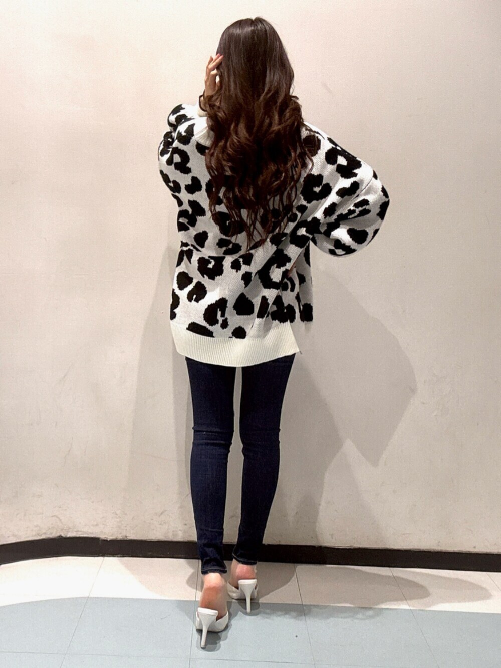 ホワイト系のカーディガン/ボレロ、ホワイト系のキャミソール、ブルー系のデニムパンツを着用したレディースの春コーディネートの3枚目の写真