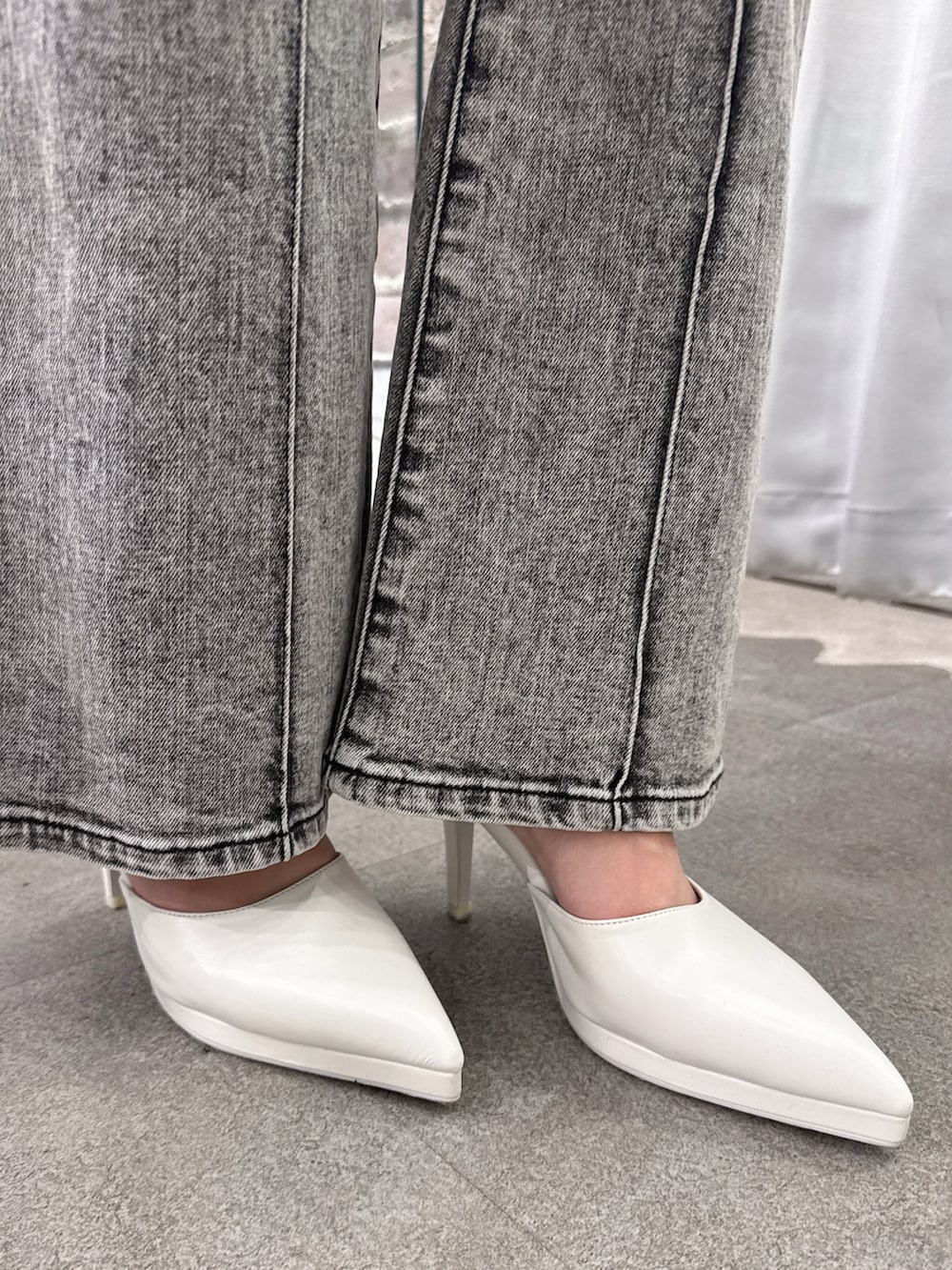 ブラック系のサロペット/オーバーオール、ホワイト系のパンプス、ホワイト系のカーディガン/ボレロを着用したレディースの春コーディネートの6枚目の写真