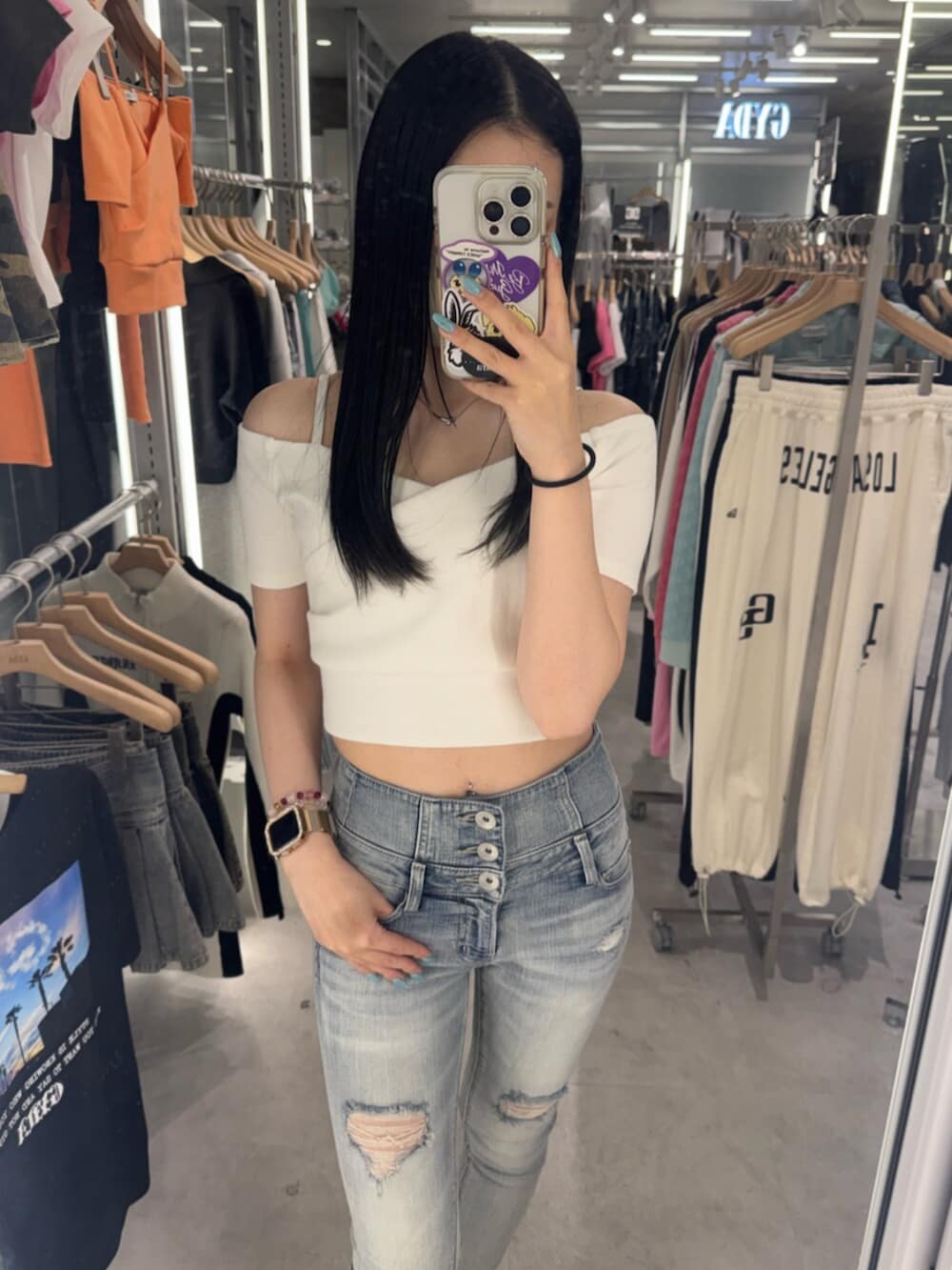 ホワイト系のTシャツ/カットソー、ブルー系のデニムパンツ、ブラック系のサンダルを着用したレディースの春コーディネートの5枚目の写真