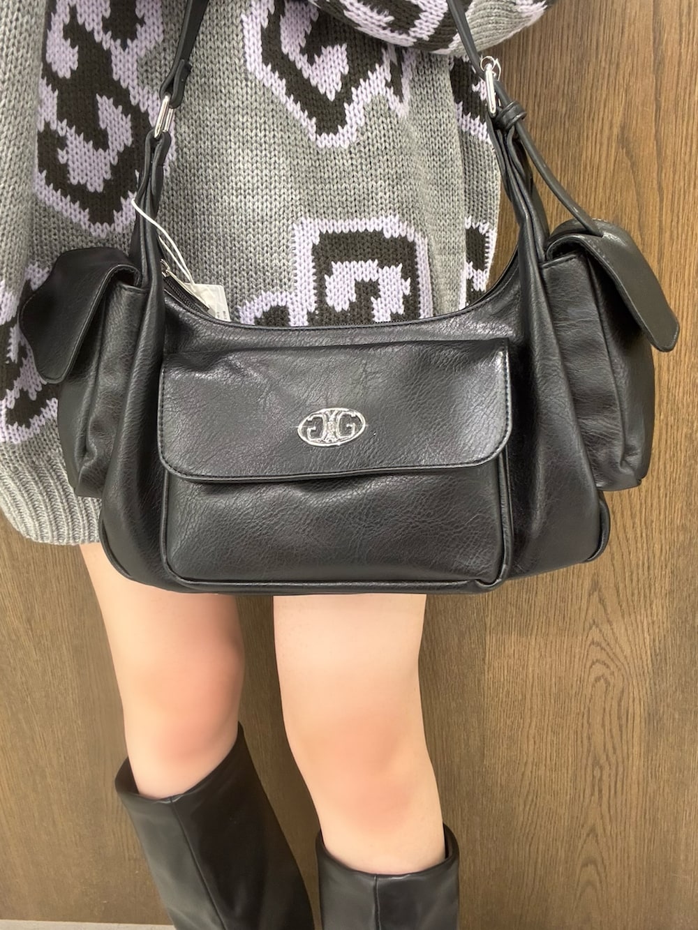 グレー系のニット/セーター、ブラック系のスカート、ブラック系のブーツを着用したレディースの秋コーディネートの5枚目の写真