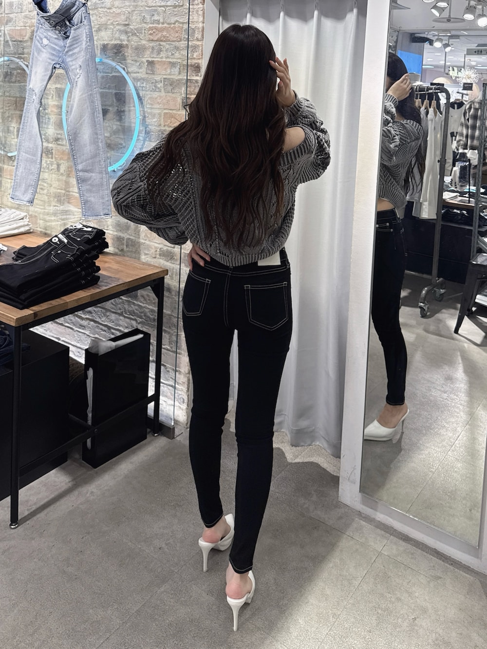 ホワイト系のキャミソール、グレー系のニット/セーター、ブラック系のデニムパンツを着用したレディースの春コーディネートの3枚目の写真