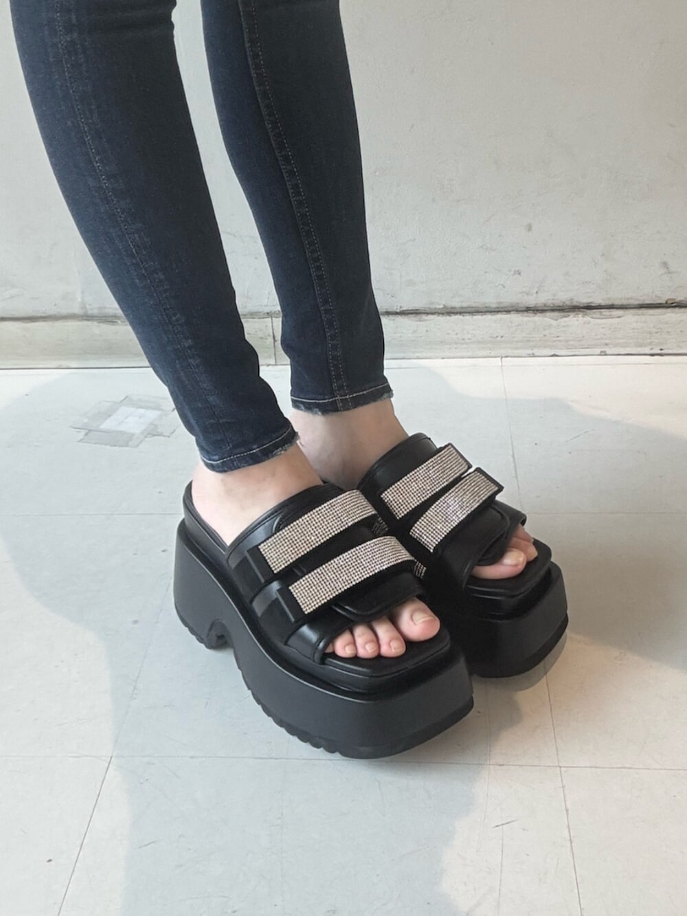 ホワイト系のチューブトップ、グレー系のカーディガン/ボレロ、ブルー系のデニムパンツを着用したレディースの春コーディネートの6枚目の写真