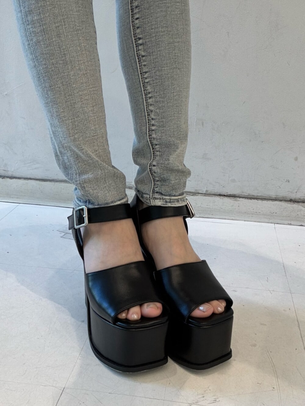 ホワイト系のTシャツ/カットソー、ブルー系のデニムパンツ、ブラック系のサンダルを着用したレディースの春コーディネートの7枚目の写真