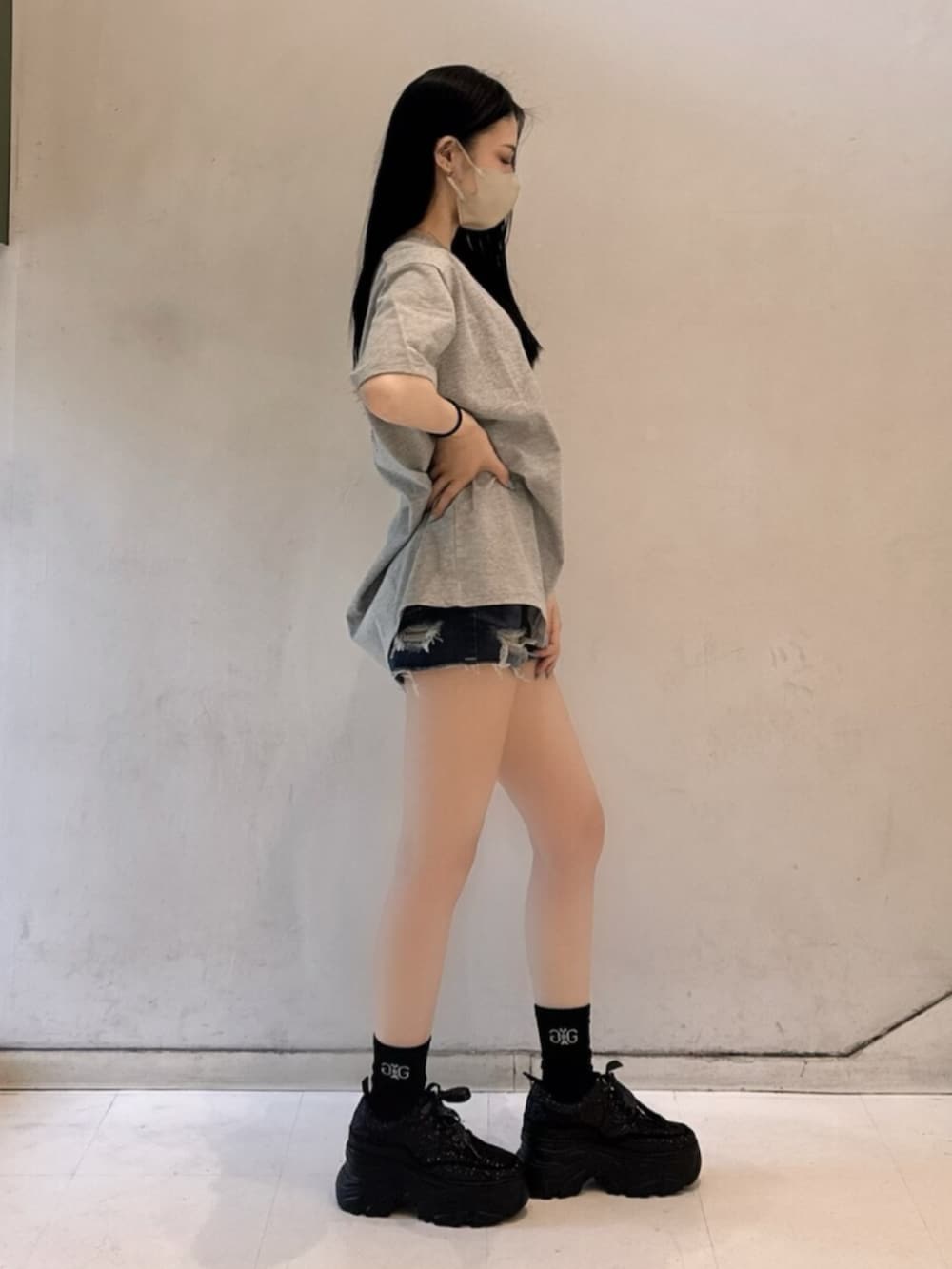 グレー系のTシャツ/カットソー、ブルー系のデニムパンツ、ブラック系のスニーカーを着用したレディースの春コーディネートの3枚目の写真