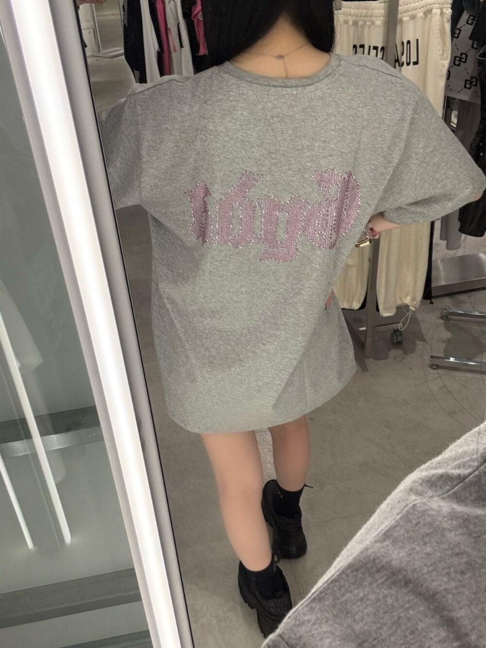 グレー系のTシャツ/カットソー、ブルー系のデニムパンツ、ブラック系のスニーカーを着用したレディースの春コーディネートの6枚目の写真