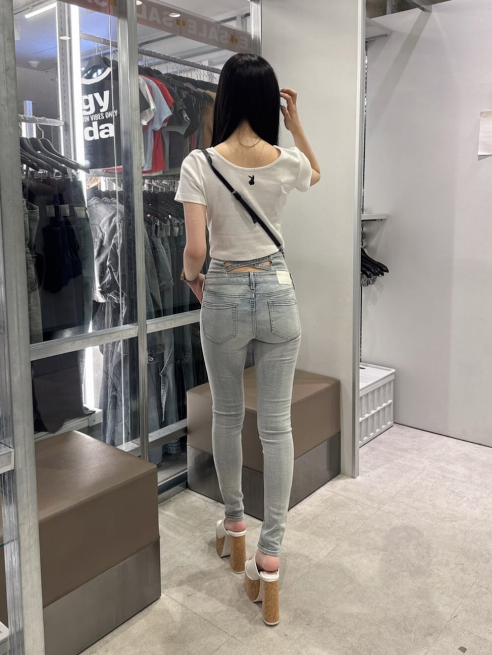 ホワイト系のサンダル、ホワイト系のTシャツ/カットソー、ブルー系のデニムパンツを着用したレディースの夏コーディネートの3枚目の写真