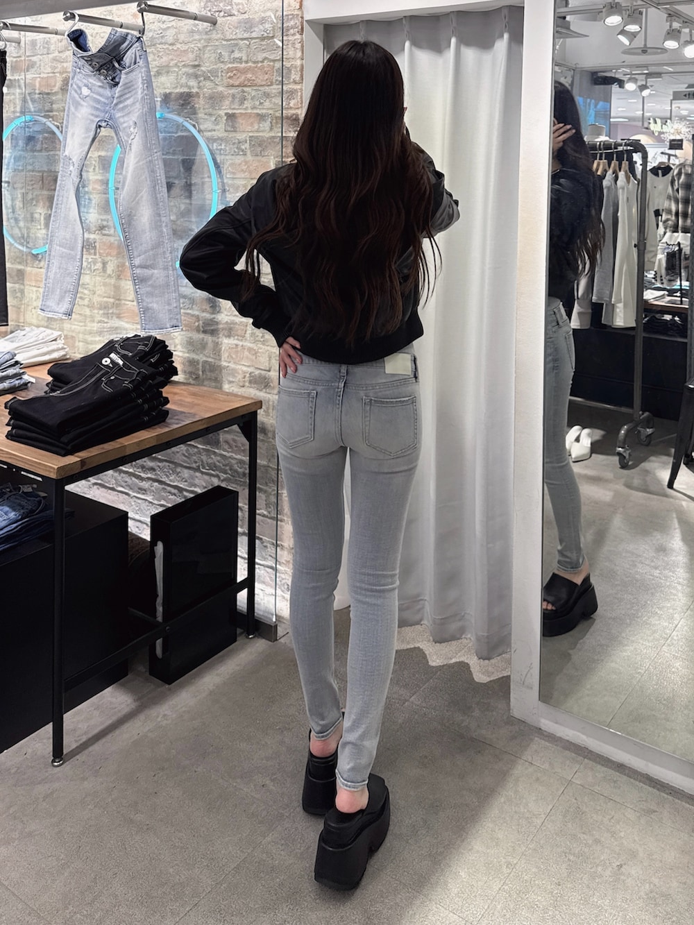 ブルー系のデニムパンツ、ホワイト系のTシャツ/カットソー、ブラック系のブルゾンを着用したレディースの春コーディネートの3枚目の写真