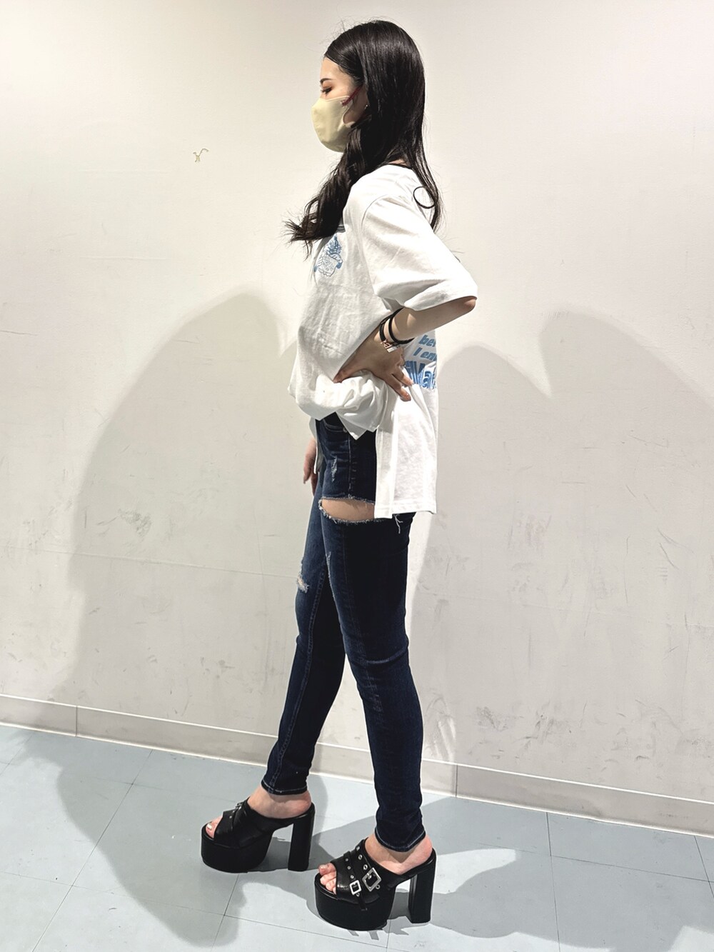 ホワイト系のTシャツ/カットソー、ブラック系のサンダル、ブルー系のデニムパンツを着用したレディースの夏コーディネートの2枚目の写真