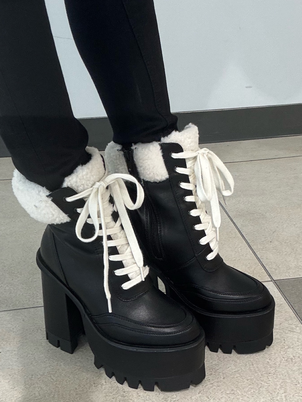 ホワイト系のニット/セーター、その他のブルゾン、ブラック系のブーツを着用したレディースの冬コーディネートの5枚目の写真