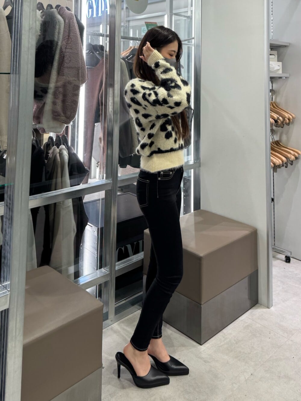 ホワイト系のニット/セーター、ブラック系のデニムパンツ、ブラック系のパンプスを着用したレディースの冬コーディネートの2枚目の写真