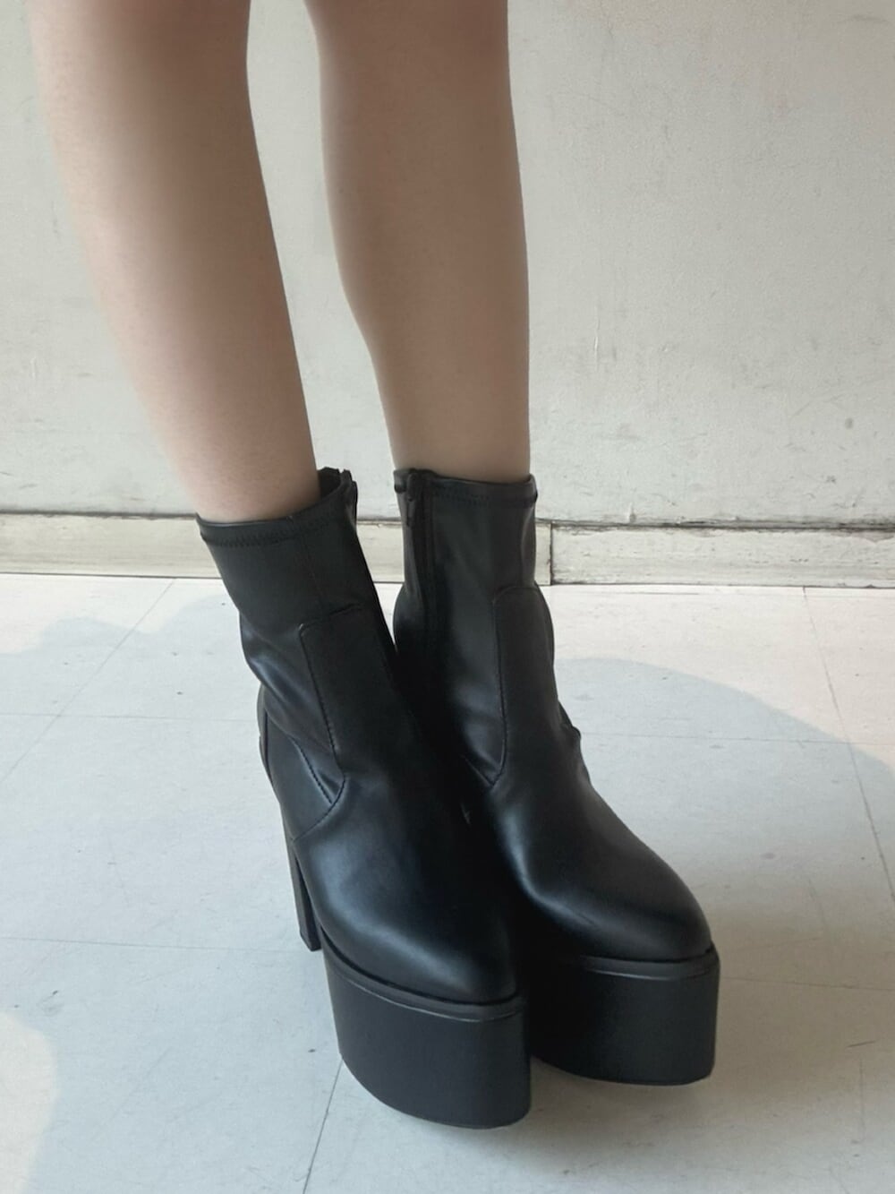 ブラック系のブーツ、ホワイト系のキャミソール、ブラック系のパーカーを着用したレディースの冬コーディネートの5枚目の写真