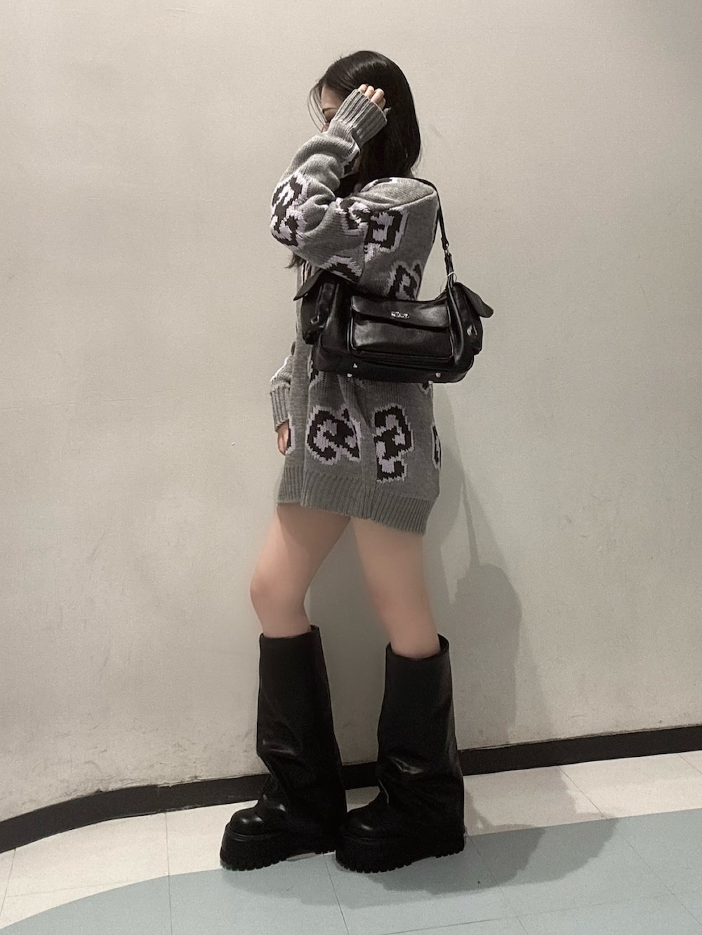 グレー系のニット/セーター、ブラック系のスカート、ブラック系のブーツを着用したレディースの秋コーディネートの3枚目の写真