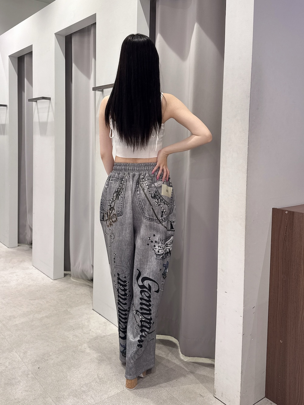 ホワイト系のキャミソール、ブラック系のデニムパンツ、ホワイト系のサンダルを着用したレディースの夏コーディネートの3枚目の写真