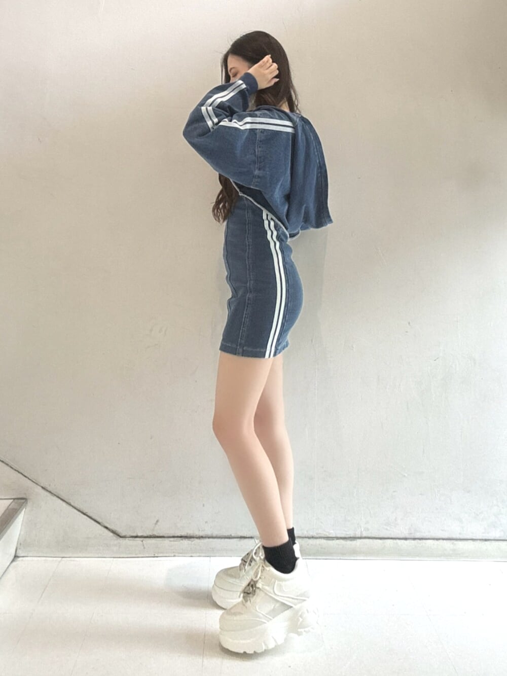 ブルー系のワンピース、ブルー系のブルゾン、ホワイト系のスニーカーを着用したレディースの春コーディネートの2枚目の写真