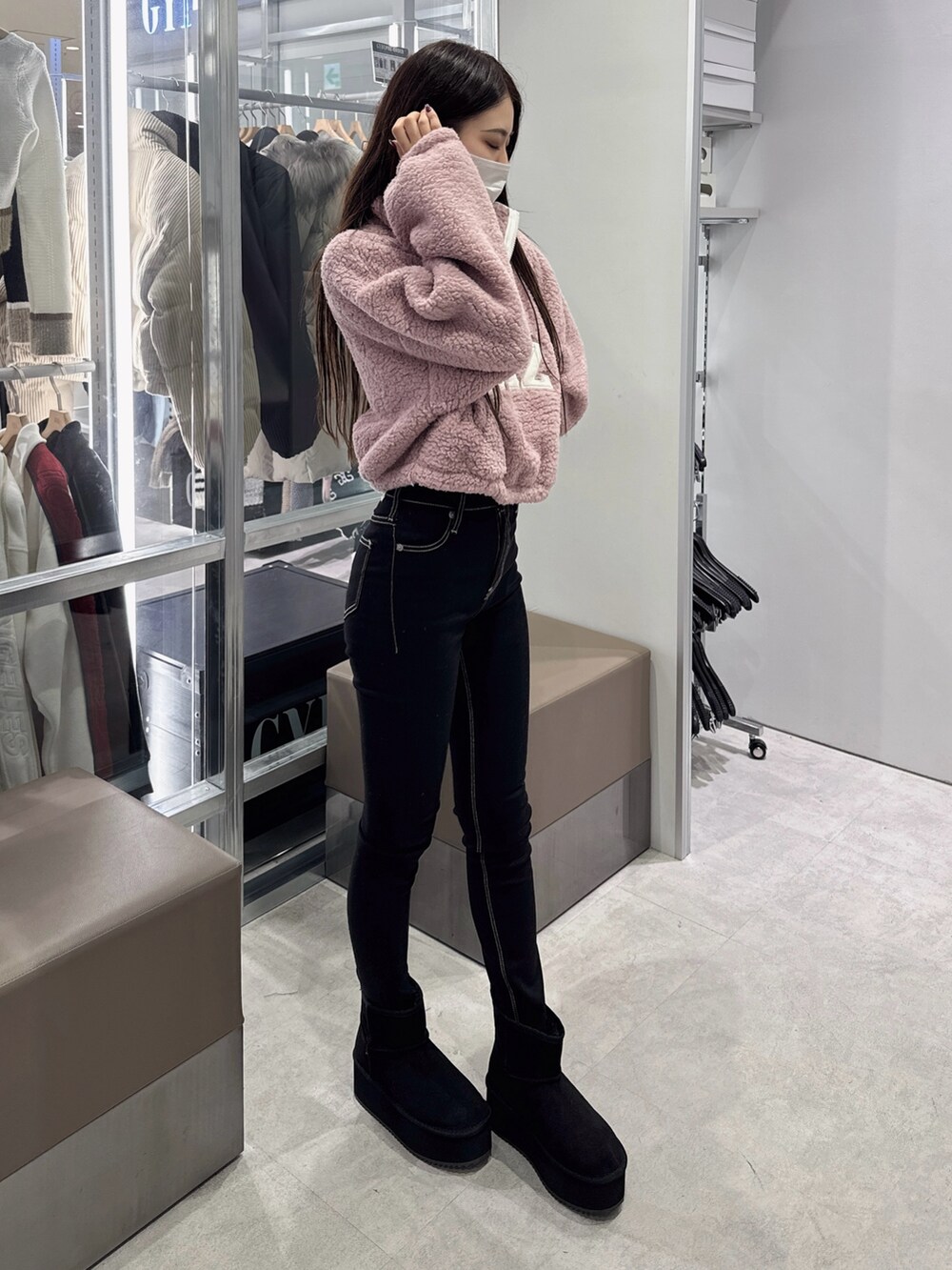 ピンク系のパーカー、ブラック系のデニムパンツ、ブラック系のブーツを着用したレディースの秋コーディネートの2枚目の写真