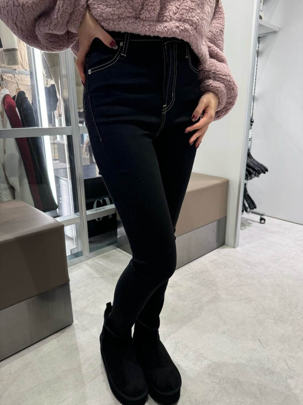 ピンク系のパーカー、ブラック系のデニムパンツ、ブラック系のブーツを着用したレディースの秋コーディネートの5枚目の写真