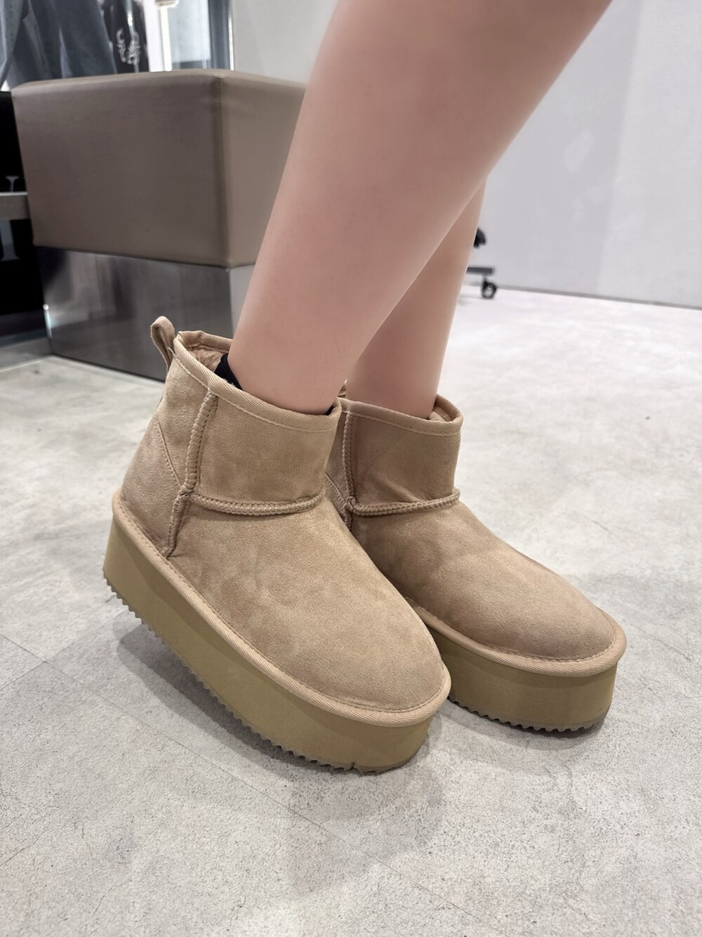 ホワイト系のニット/セーター、ブラック系のデニムスカート、ベージュ系のブーツを着用したレディースの秋コーディネートの5枚目の写真